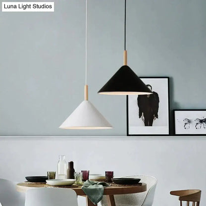Two minimalist nordic simple kitchen pendant lights with black and white matte conical shades and wooden dowel suspension