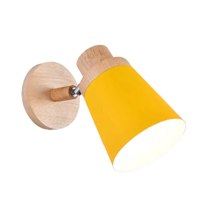 A nordic style wall light with a natural wood base and yellow coolie shade for baby room inch fixture