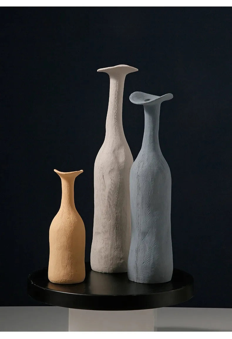 Three minimalist ceramic vases in beige off-white and muted blue with textured surfaces for Nordic home decoration