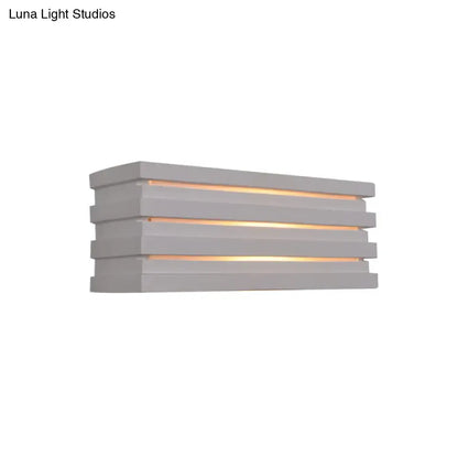 Modern gray bedroom wall sconce with nordic style louvered design and warm ambient glow from horizontal slats