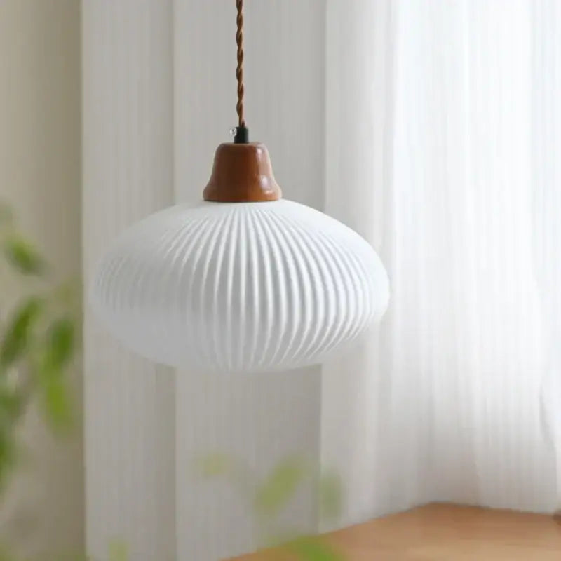 White ribbed glass pendant light with decorbites brown wood top and twisted brown wood led cord for dining room decor