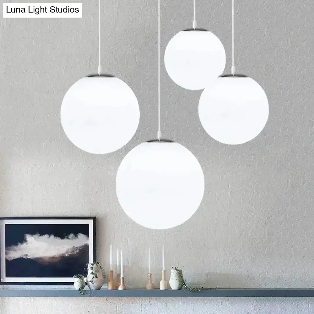 Set of four nordic white glass ball pendant lights with frosted glass shades and minimalist metal fixtures for living room