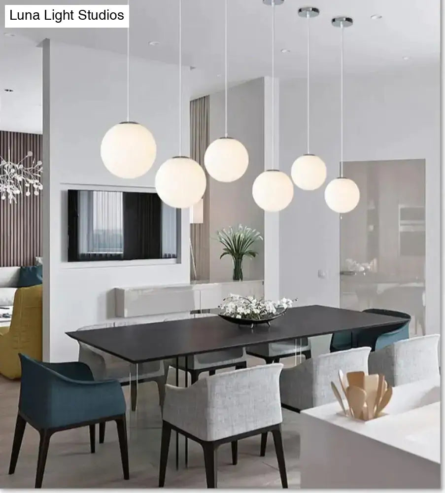 Modern decorbites pendant lights featuring nordic white glass ball design hanging in a living room setting