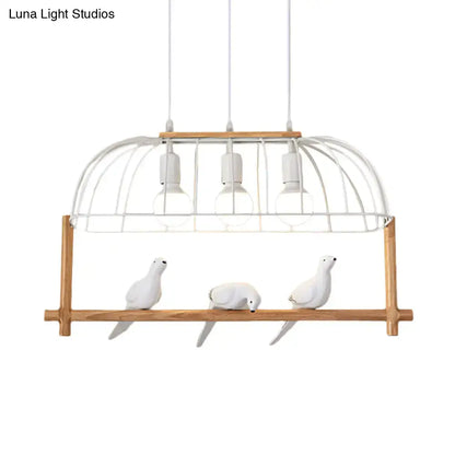 White ceramic bird figurines sit on a wooden shelf beneath a DecorBites™ nordic style white iron island pendant fixture