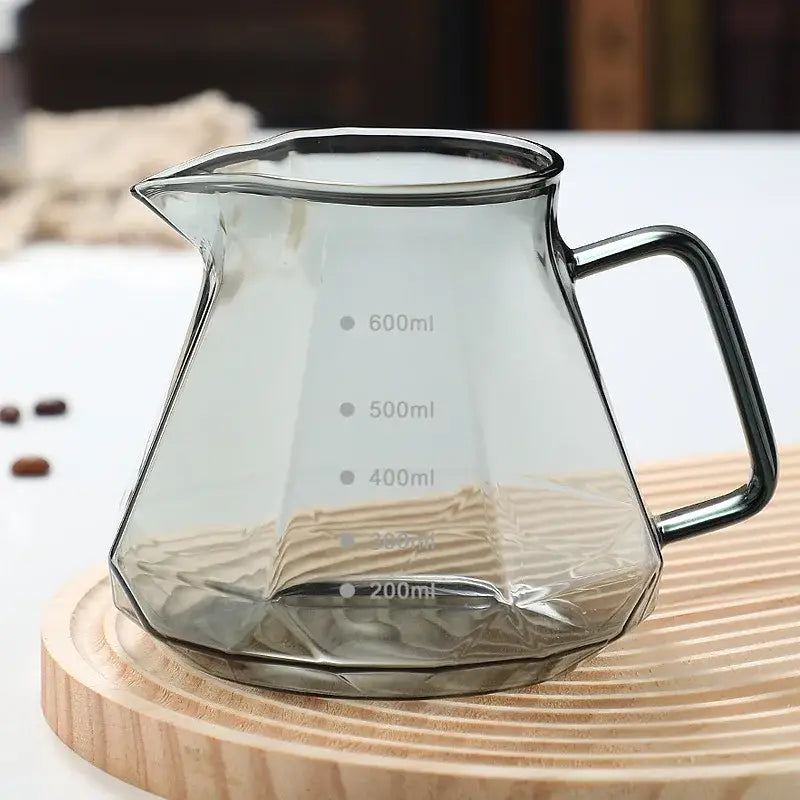 Octagonal glass coffee kettle with clear faceted dripper and black metal handle featuring ml measurement markings