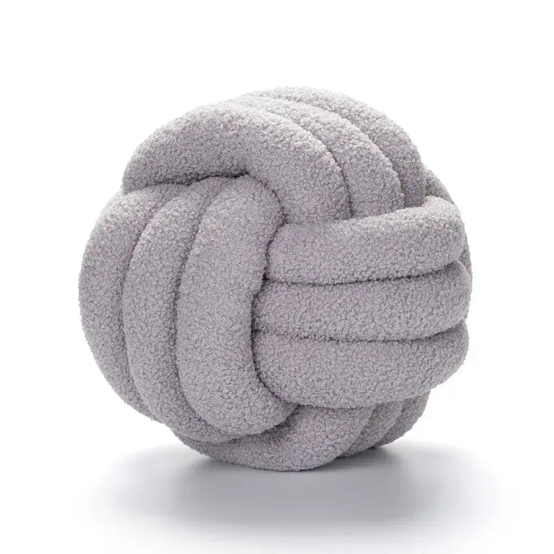 A soft light gray boucle knotted circle plush throw pillow made of textured fleece for bedroom decorbites decor
