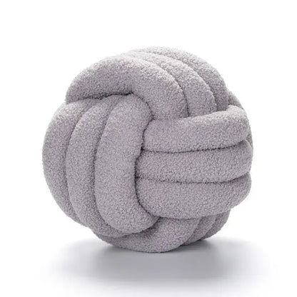 A soft light gray boucle knotted circle plush throw pillow made of textured fleece for bedroom decorbites decor