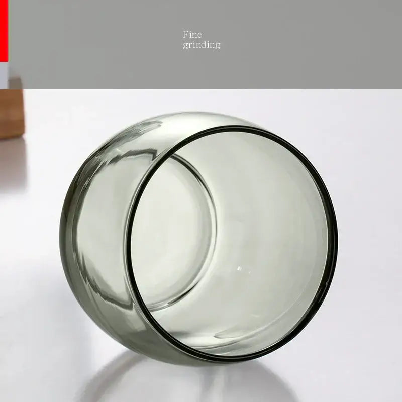 A translucent gray glass tea cup with a smooth rounded rim from the olive green glass tea cup set for decorbites tea
