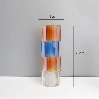A modern clear crystal mosaic vase in gradient orange and blue acrylic serving as a living room candle holder