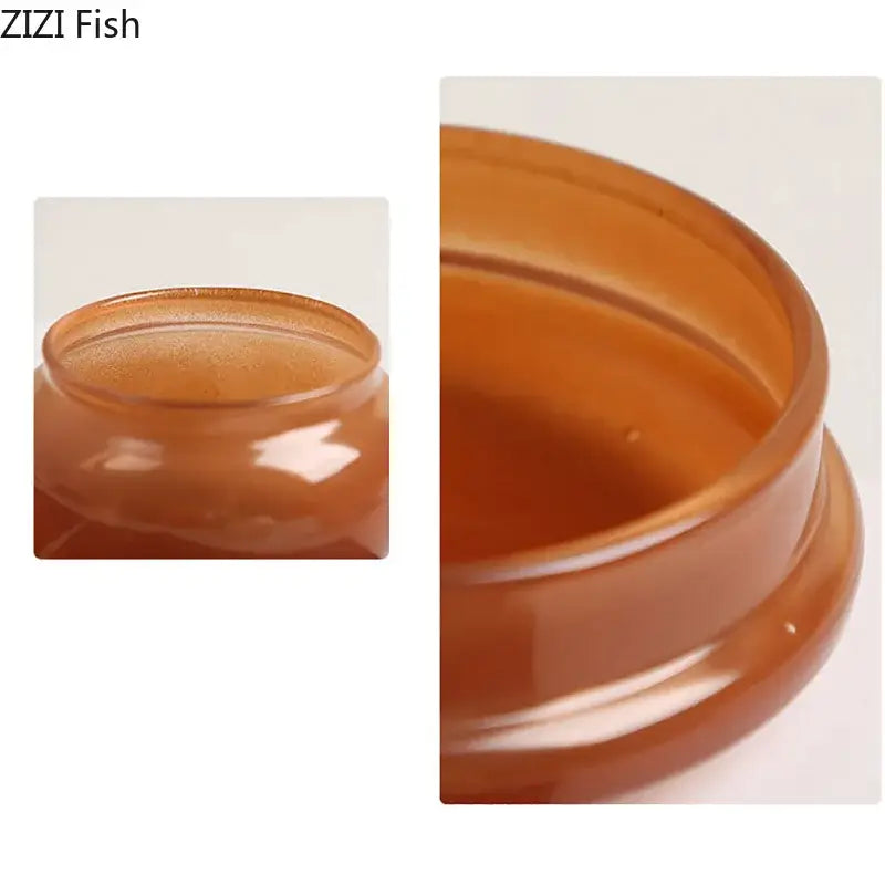 Amber-colored glossy plastic storage jar with smooth rounded rim and flared base in orange and blue glass storage jar set