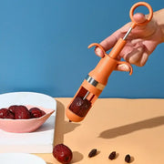 Orange metal cherry pitter fruit core remover with ring handle and dual grips for easy red date pit removal