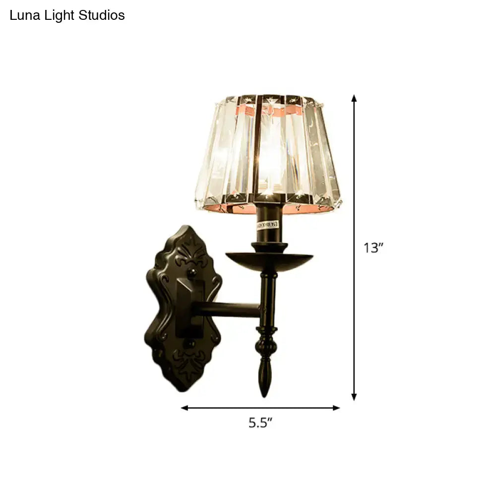 Antique bronze-finished wall light with faceted crystal prisms in a black finish for bedroom sconce lighting