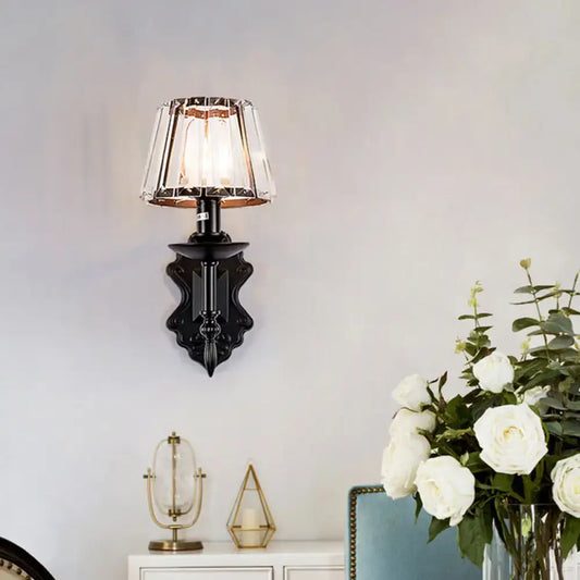 Ornate black finish wall light with faceted crystal prisms for elegant bedroom sconce lighting