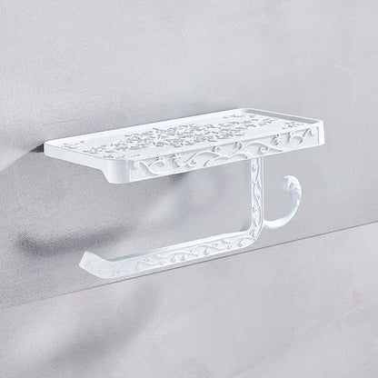 White ornate metal toilet paper holder with intricate floral scrollwork for bathroom storage with phone shelf