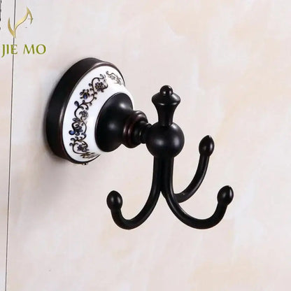 Ornate black wrought iron triple hook wall mount with white ceramic blue floral base in bathroom accessories set