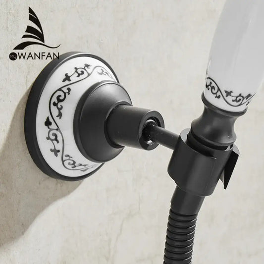 Ornate black and white ceramic wall-mounted shower mount bracket with scrollwork design for handheld shower use