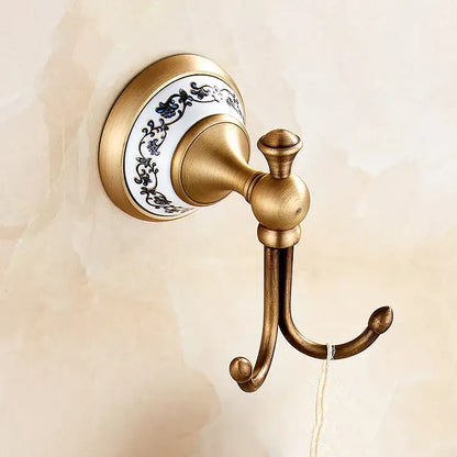 Antique brass double hook with white ceramic backplate featuring blue floral patterns from bath hardware set