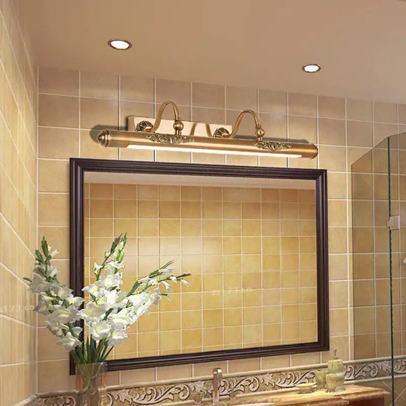 Ornate brass bathroom mirror lamp with decorative scrollwork and curved arms for elegant bathroom mirror lighting