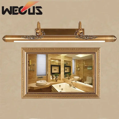 Ornate brass bathroom mirror lamp with gold finish, decorative scrollwork ends, and sleek modern led strip light