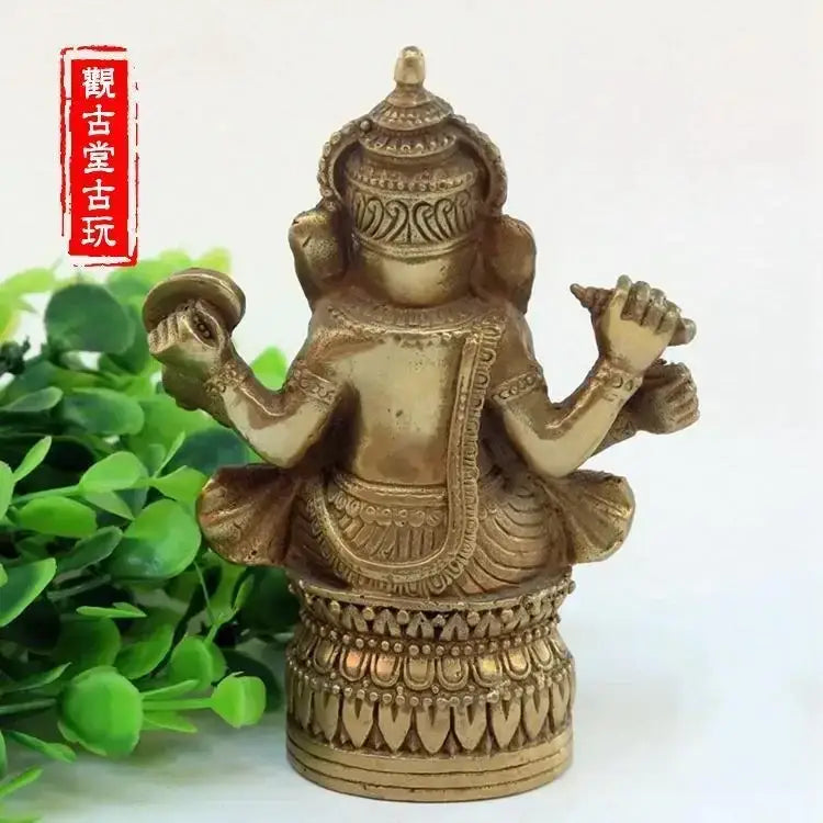 Ornate golden brass bronze ganapati elephant statue with four arms in traditional attire for living room decor