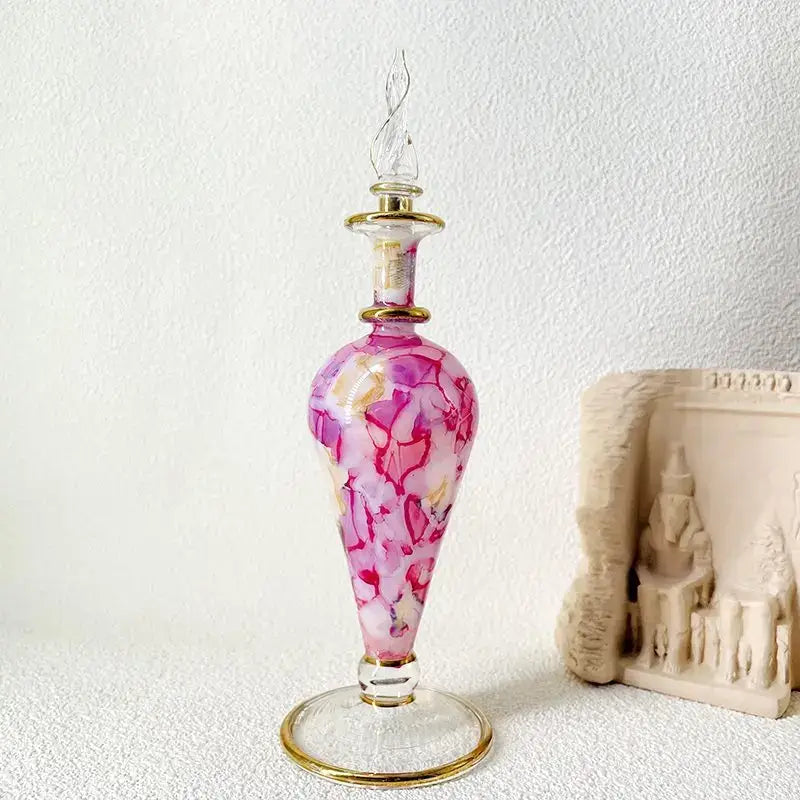 Ornate pink and white marbled glass bottle jewelry ornament with gold-toned metal accents for bedroom decor
