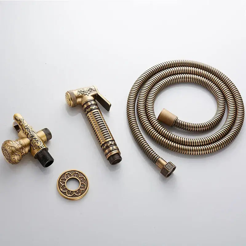 Ornate engraved gold brass wall mounted bidet faucet with antique brass finish and detailed decorbites brass wall sprayer