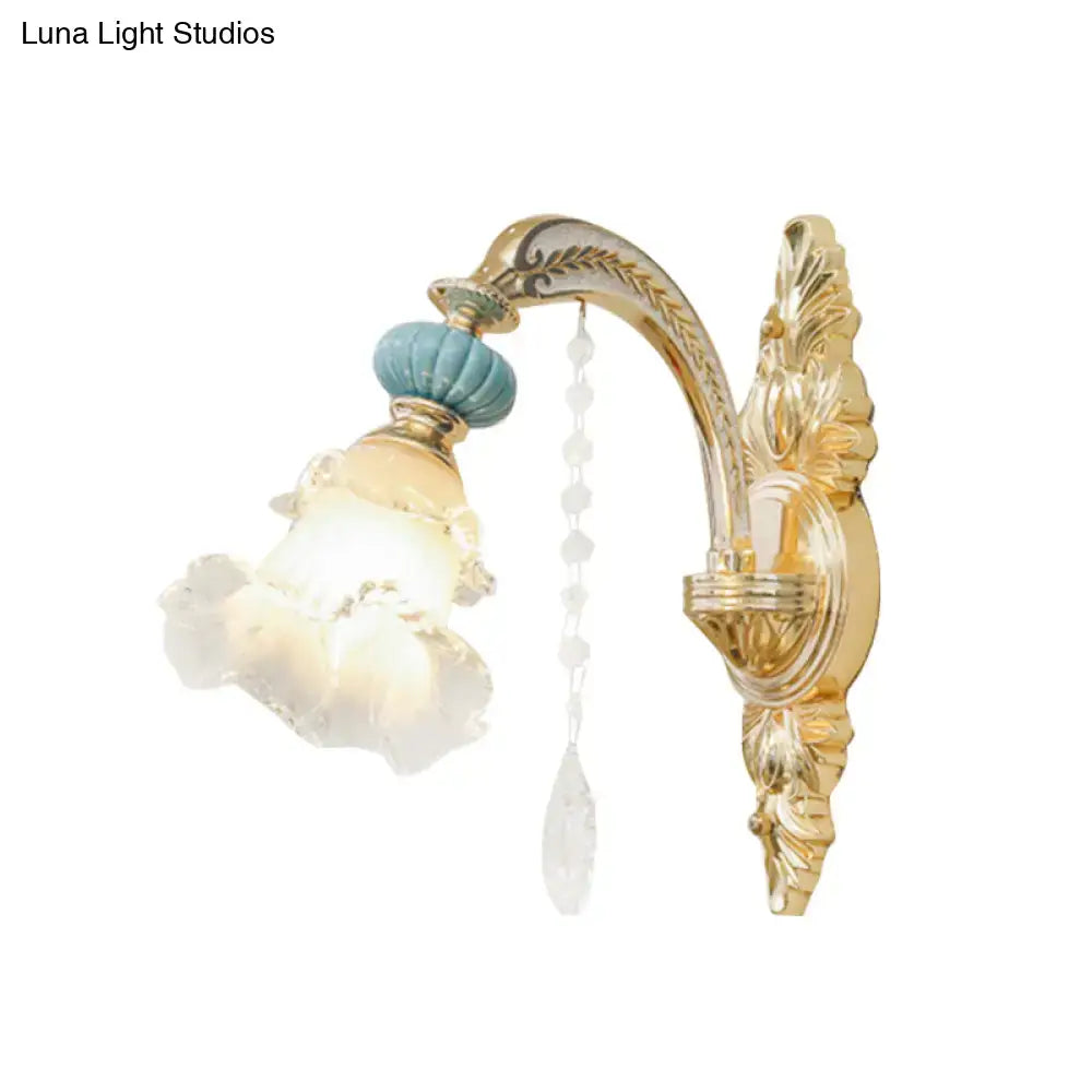 Ornate gold and blue glass wall mount light with teal ceramic finial and crystal beads for bedroom illumination