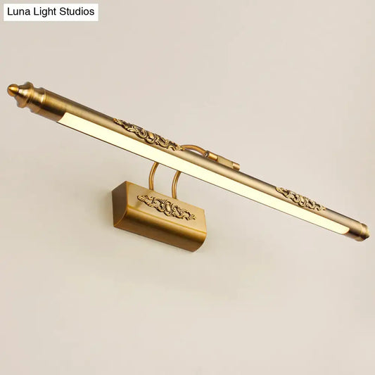 Ornate gold-toned brass wall vanity light with scrollwork detailing and warm white glow for bedroom sconce lighting