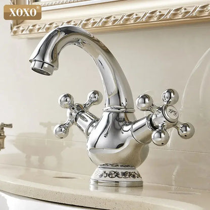 Chrome finished xoxo basin faucet with ornate double handle chrome cross-shaped handles and decorative scrollwork base