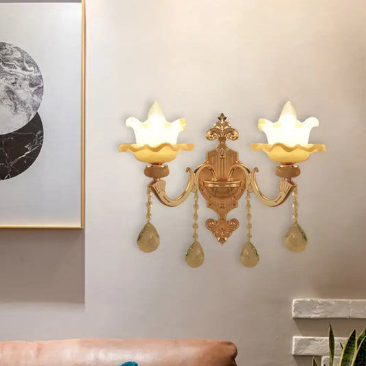 Ornate gold crystal wall sconce with frosted glass shade and teardrop pendants for living room lighting