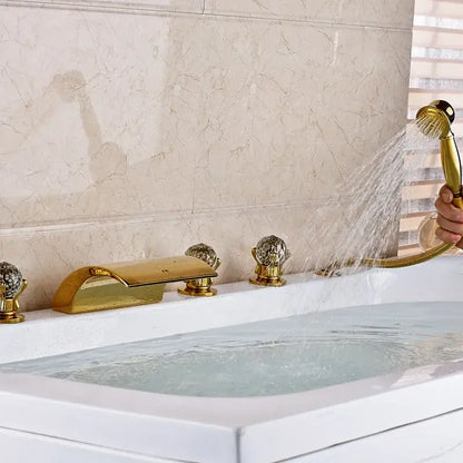 Ornate gold-toned bath tub faucet with crystal knobs and sleek modern design featuring a led waterfall and handshower