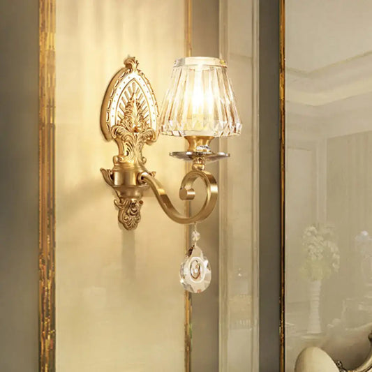Ornate gold wall sconce contemporary with faceted crystal shade and dangling crystal pendant for bedroom lighting