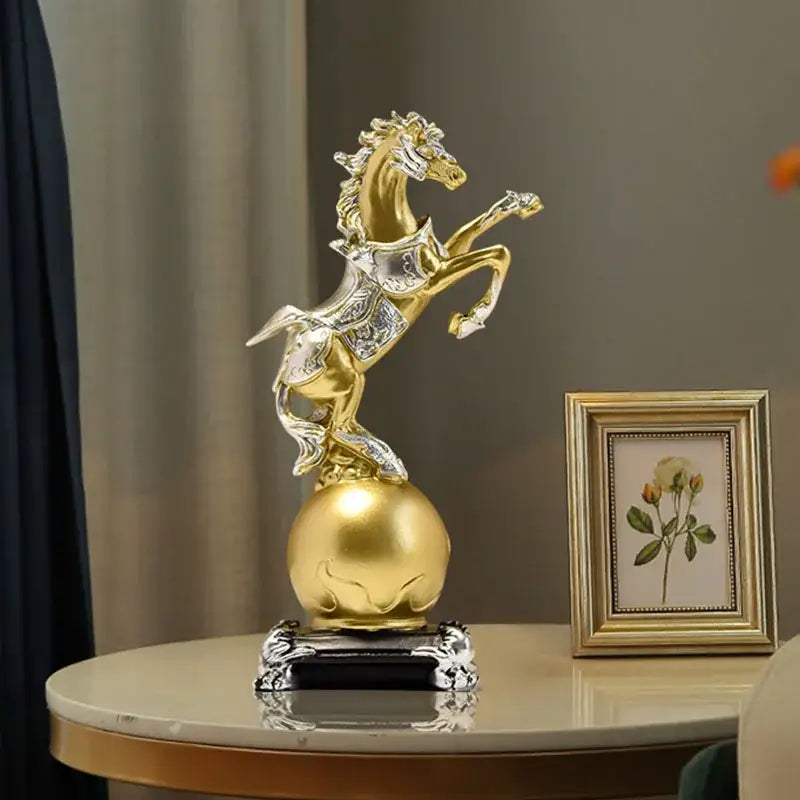 Ornate decorbites golden horse sculpture in gold and silver standing on a polished gold sphere with black base for living room