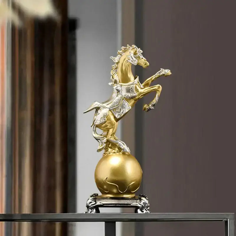 Ornate decorbites golden horse sculpture in gold and silver with intricate detailing standing on a decorative sphere
