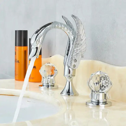 Ornate gold swan basin faucet with chrome finish and crystal knob handles featuring detailed feather decorbites gold swan design