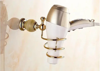 Gold-toned wall-mounted hair dryer holder with polished brass finish cradling white silver dryer from decorbites brass jade hardware set