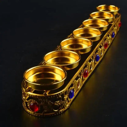 Ornate golden gem inlaid candlestick stand with six compartments decorated with red and blue gemstones for wedding decor