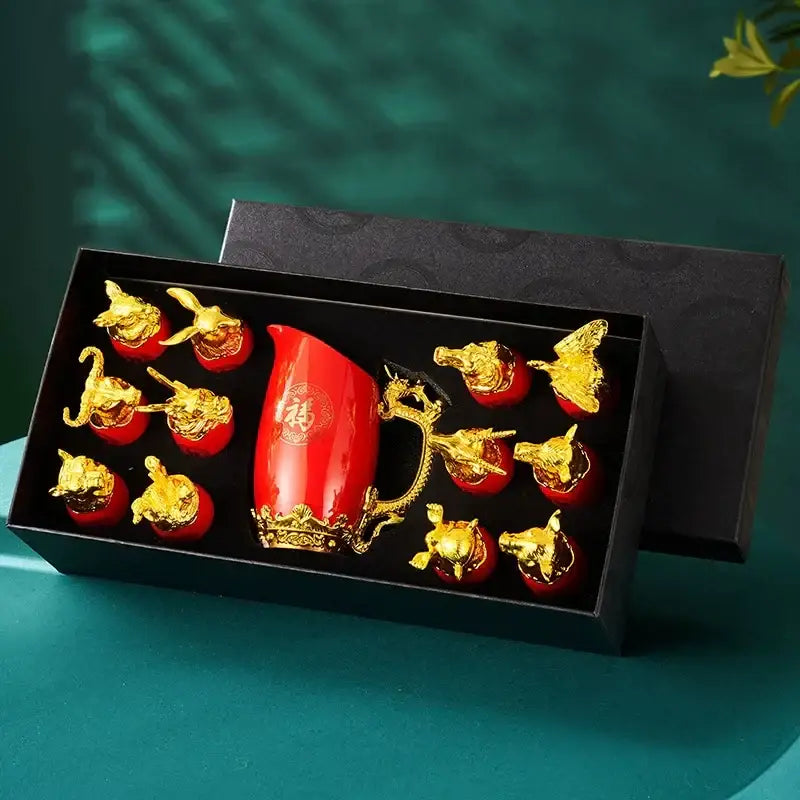 Red ceramic tea set with gold dragon handle and golden ceramic animal head figurines on decorbites silver floral tray