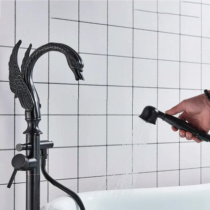 Black swan-shaped black bathtub faucet with ornate winged design and matching handheld showerhead by decorbites