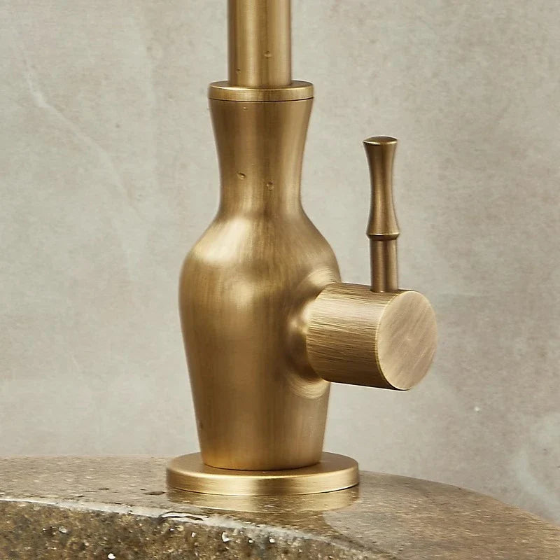 Brass-finished single hole outdoor antifreeze faucet with sleek vase-like body and 360° swivel cylindrical spout