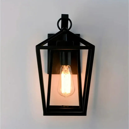 Black wrought iron outdoor wall light with glass shades featuring a glowing filament bulb for outdoor wall use