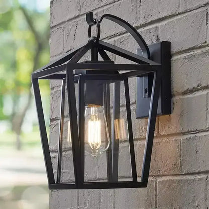 Black wrought iron outdoor wall light with glass shades and exposed filament bulb for waterproof outdoor use