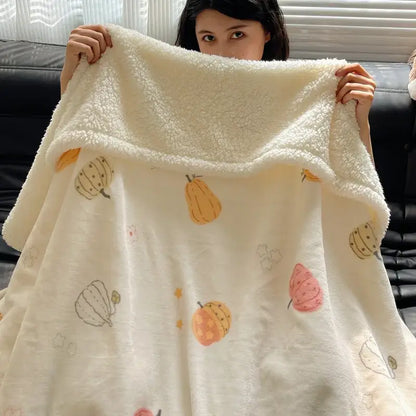 A cream-colored decorbites cozy fleece blanket with playful orange pink and yellow pumpkins in a panda pattern design