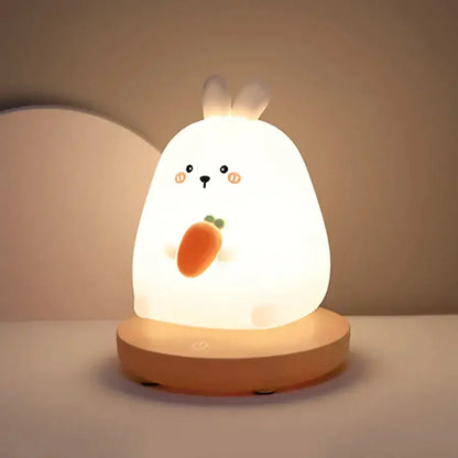 A soft glowing white rabbit kids animal silicone night light with carrot design and wooden base for bedroom decorbites decor