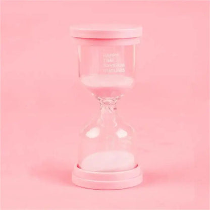 Pink glass hourglass with white sand and pink lid from a pastel blue and pink sand timer set for kids bedroom decor
