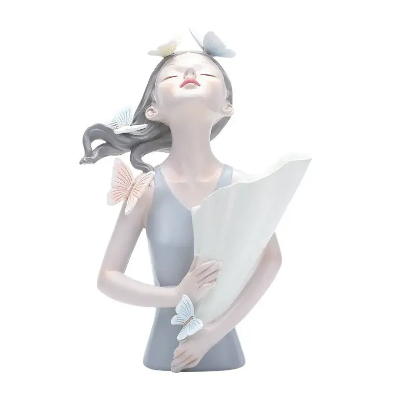 A delicate gray resin butterfly girl figurine holding a white fan with pastel butterflies for flower vase decor