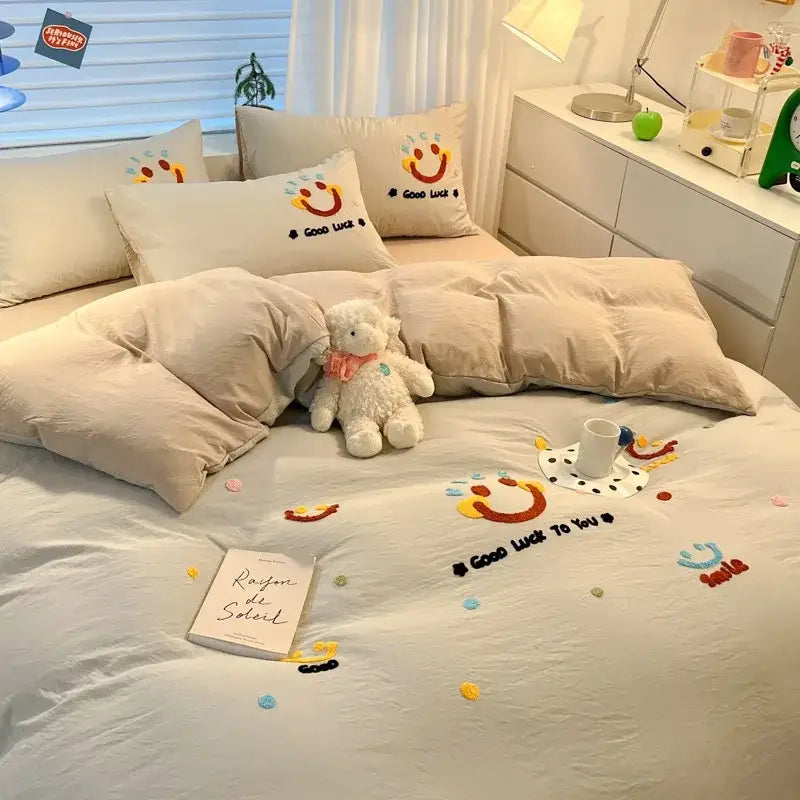 Beige pastel cartoon embroidered cotton bedding set with cheerful smiley face designs and good luck text decorbites cartoon embroidered