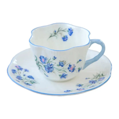 A delicate white porcelain coffee cup and saucer set with blue cornflower floral pattern from decorbites bone collection