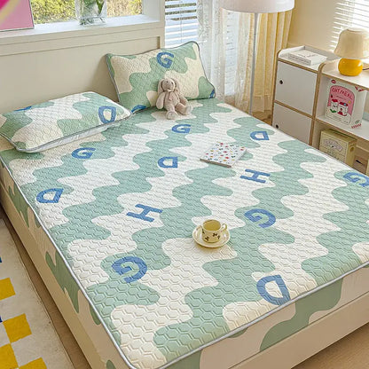 Pastel floral quilted latex fitted sheet set with soft mint green and white quilted bed pad featuring blue embroidered letters