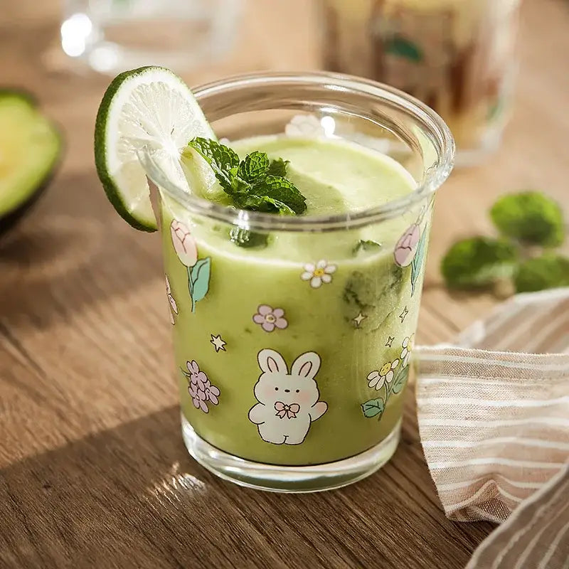 Pastel floral rabbit glass tea coffee cup featuring a clear glass tumbler with a white bunny and green smoothie